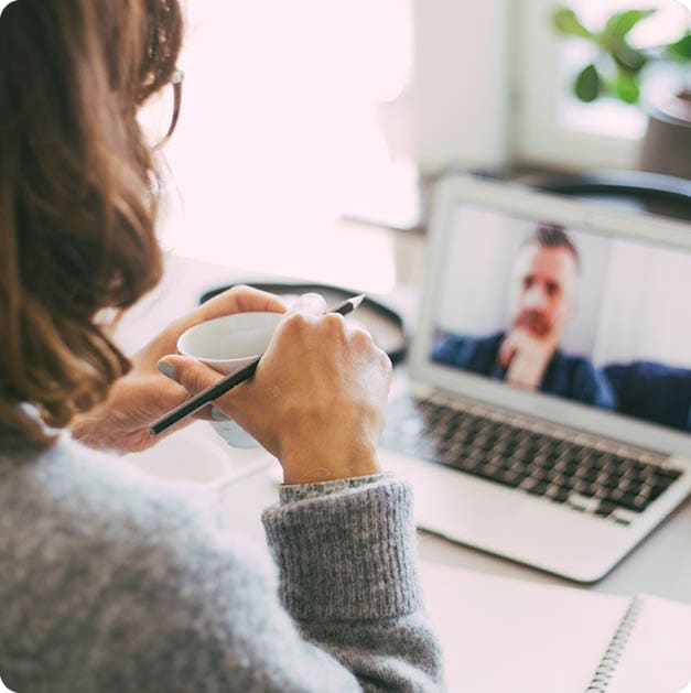 Woman in home office having online meeting with coworker