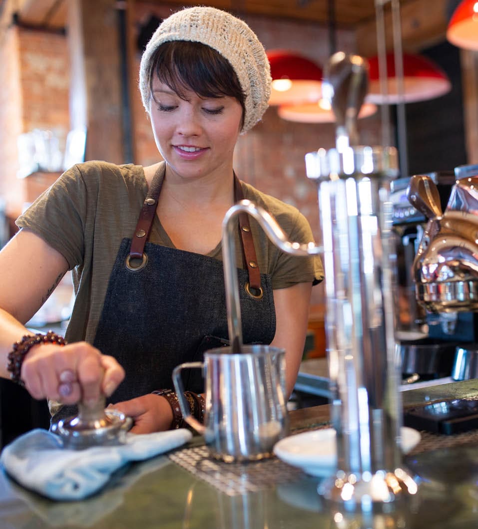 Barista using espresso machine in coffee shop